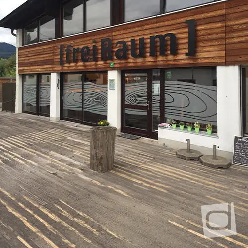 Design-Sichtschutzfolie in Holz-Jahresring-Optik an Glasfront mit freier Sicht von innen nach außen im Freiraum Brannenburg